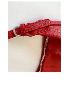 Detail of red lychee leather bag with silver metal buckle and premium stitching