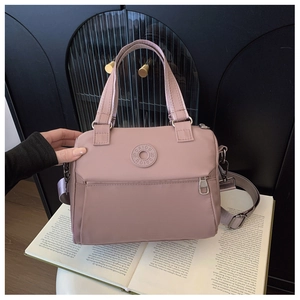 Detailed close-up of pink nylon crossbody bag with silver zippers and DAIOU logo