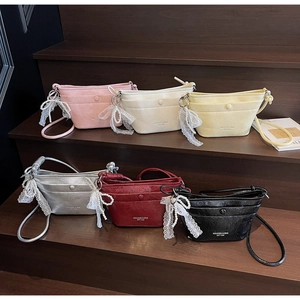 Close-up of stylish mini crossbody bucket bags in six colors with pearl bow charms