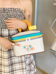 Cute house-shaped toiletry bag with yellow handle and colorful zipper details