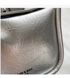 Detail of silver pleated texture bag featuring fine metallic finish and high-quality stitching