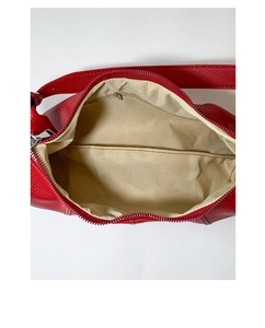 Detail view of red lychee grain leather dumpling bag interior with beige fabric lining