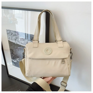 Detail of off-white nylon crossbody bag showing the round logo and adjustable shoulder strap