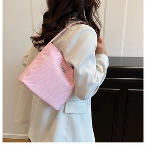 Detail of pink pleated canvas hobo bag showing silky texture and brand tag on strap