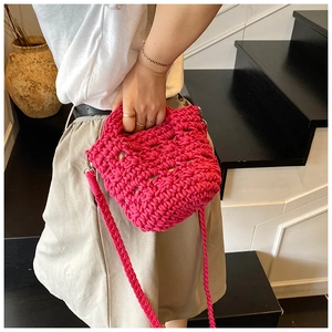 Detailed texture of thick crochet knit cotton straps and weave on a rose red bucket bag