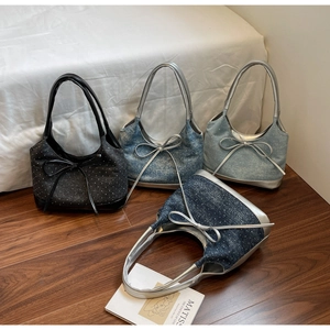 Close-up of four denim tote bags in black and blue shades with large bow details