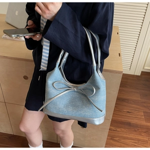 Close-up of denim tote bag with silver bow accent and sparkly rhinestone detailing