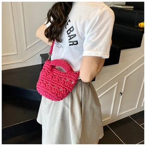 Detailed texture of rose red crochet bucket bag with handmade knit patterns and strap