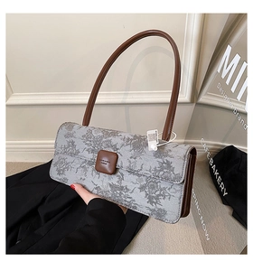 Détail du tissu à imprimé paysage vintage et de la bandoulière en cuir du sac baguette