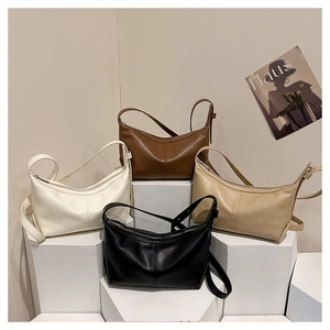 Minimalist half-moon shoulder bags in four colors arranged on geometric stands