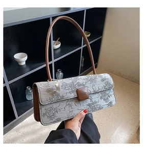 Détail du sac à bandoulière en tissu jacquard à motifs floraux et finitions en cuir