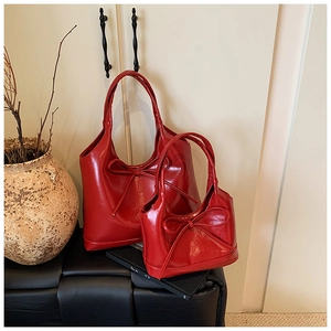 Detail view of two-piece red oil wax leather tote bags with elegant bow decorations