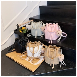 Detailed view of mini drawstring bucket bags in five colors with cute bear charms