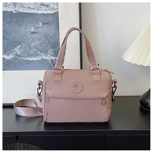 Detail of dusty pink nylon tote bag with DAIOU rubber logo and wide fabric strap
