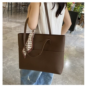 Large dark brown tote bag with houndstooth scarf detail shown on shoulder for daily commute