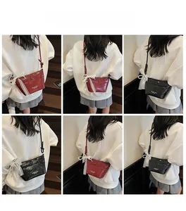 Close-up of stylish crossbody bag with lace bow decoration in red and black