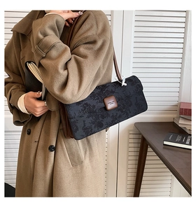 Détail du sac baguette rétro français avec motif texturé et bandoulière en cuir brun