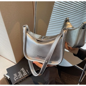 Detail of silver metallic crescent bag with crinkled texture and logo metal twist lock