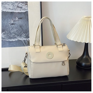 Detail of the cream nylon crossbody bag showing the DAIOU logo and zip pocket