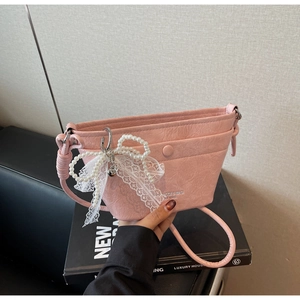 Pink pleated leather crossbody bag featuring a delicate lace butterfly beaded charm detail