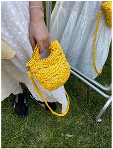 Detailed shot of yellow hand-crocheted mini bucket bag with thick cotton rope and woven strap