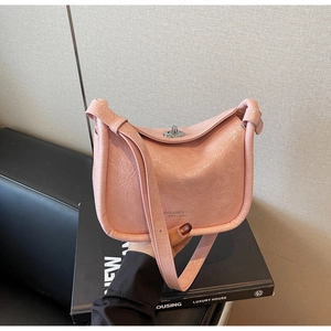 Detail of pink pleated leather crossbody bag with silver twist lock and wide shoulder strap