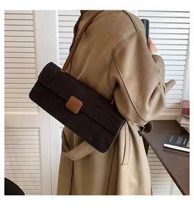 Détail du sac baguette vintage avec texture mate et boucle en cuir marron contrastée