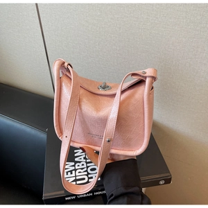 Detail of pink glossy crinkled leather crossbody bag with silver twist lock and branding