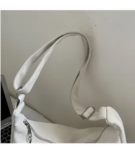 Detail of adjustable wide shoulder strap and silver zipper on white dumpling bag