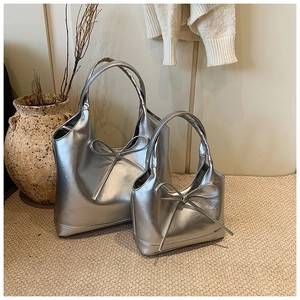 Macro shot of silver metallic wax leather tote bags with bow detailing in two sizes