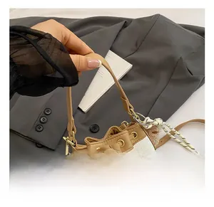 Detail of color-block bucket bag in white lychee leather with gold hardware and tassel