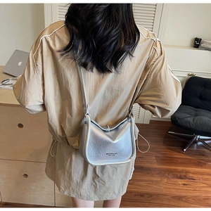 Rear view of silver metallic crossbody bag with pleated leather texture on model