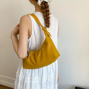 Close-up of yellow leather hobo bag with adjustable strap and detailed side stitching