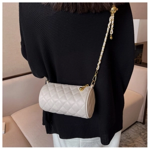 Gros plan du sac cylindrique blanc matelassé avec chaîne dorée et cuir PU de qualité