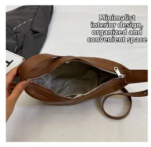 Top view of the brown leather bag interior with grey lining and smooth zipper detail