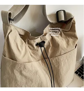 Detail of khaki nylon bucket bag showing drawstring closure and adjustable woven shoulder strap