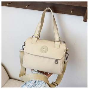 Detail of beige nylon square crossbody bag with wide strap and circular logo detail