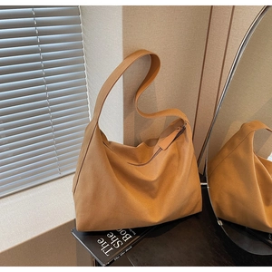 Dettaglio della borsa tote in finta pelle scamosciata color caramello dal design minimalista