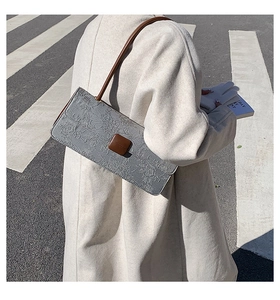 Détail du sac sous le bras rectangulaire gris gaufré avec bandoulière marron