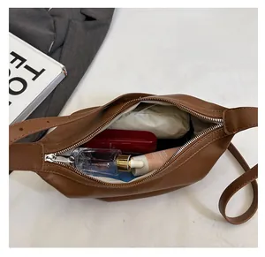Detail view of the spacious interior of this brown leather crescent crossbody bag