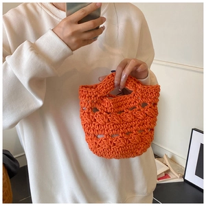 Detail of hand-crocheted orange hollow bucket bag with intricate woven patterns for summer