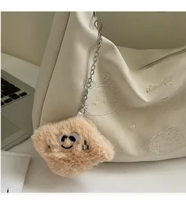 Detailed view of cream PU crossbody bag featuring cute cat embroidery and soft smiling charm