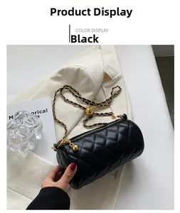 Détail du sac cylindre matelassé noir avec bandoulière chaîne et sphère dorée