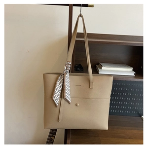 Detail of khaki pebbled leather tote bag with geometric scarf and magnetic clasp closure
