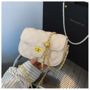 Detail view of beige quilted crossbody bag with golden chain and square metal lock