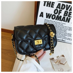 Detail of black quilted leather shoulder bag featuring gold chain and ball adjustment