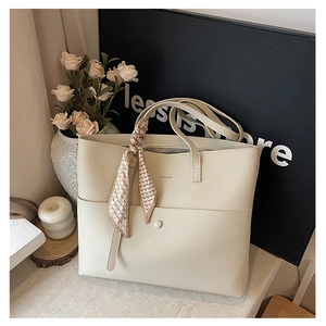 Detail of beige lychee texture tote bag with silk scarf and front snap pocket