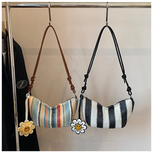 Detail of woven crescent shoulder bags with striped patterns and sunflower charms