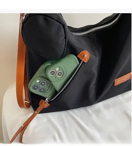 Detail of black nylon tote bag featuring front zipper pocket holding two smartphones