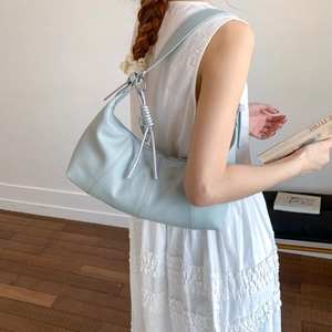 Detail of light blue pebble leather hobo bag with textured finish and silver hardware